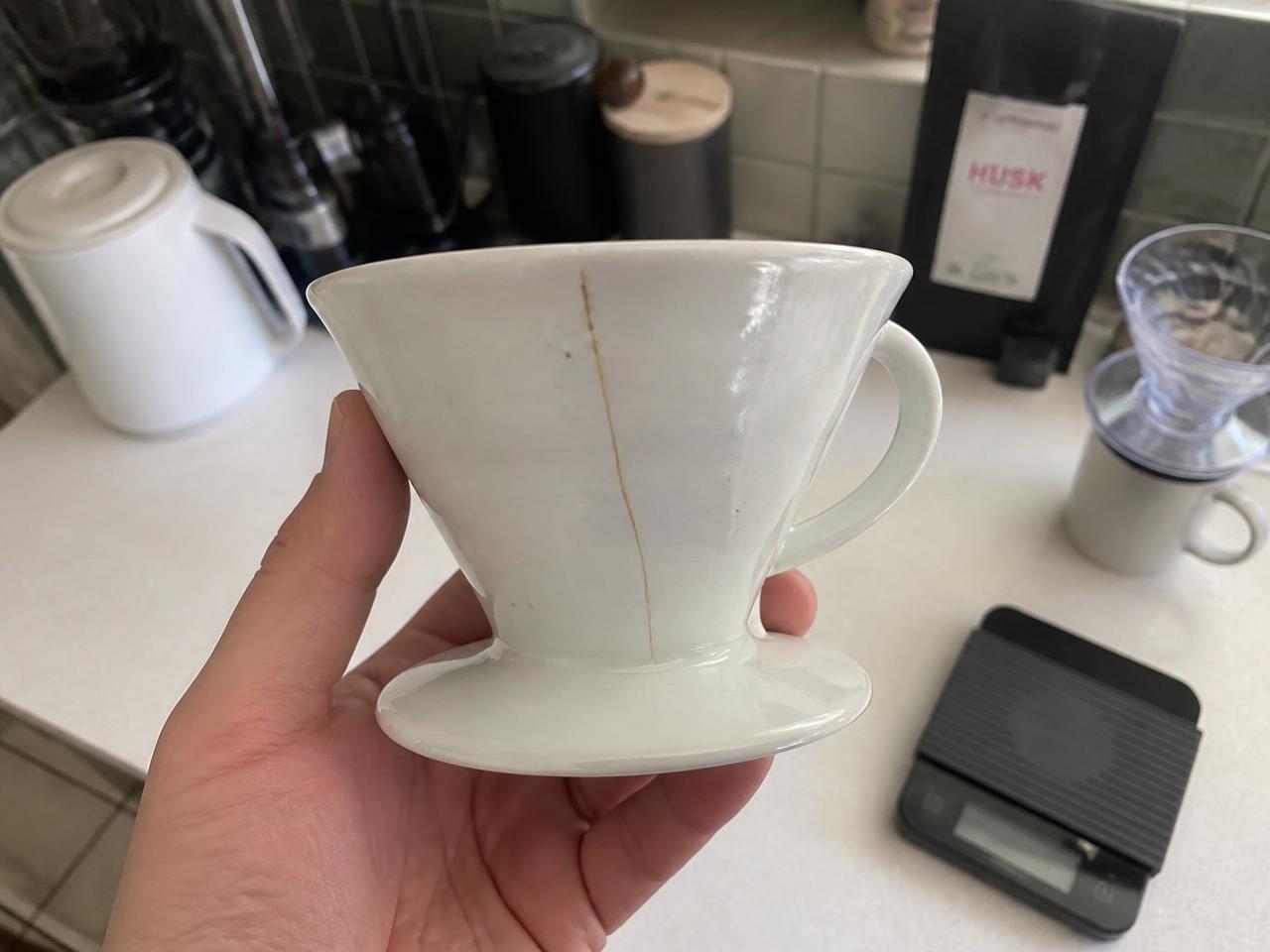 Ceramic pour-over dripper with a long hairline crack down the side